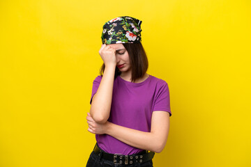 Young Ukrainian woman isolated on yellow background with headache