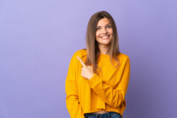 Young Slovak woman isolated on purple background pointing to the side to present a product