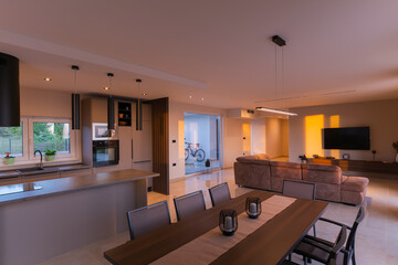  Modern, bright living room featuring a comfortable sofa and panoramic glass doors opening to a...