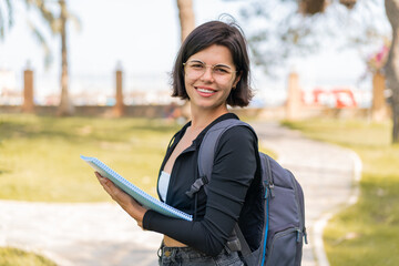 Young Bulgarian student woman at outdoors smiling a lot