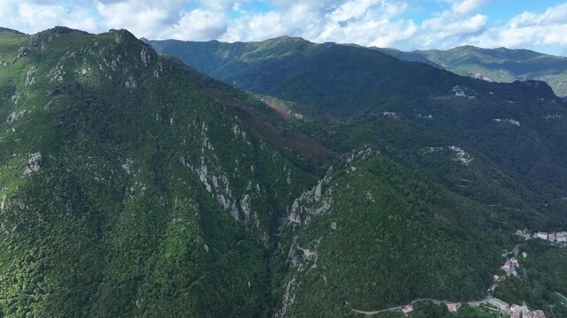 Aerial view of Corsican mountains with lush green valleys and blue skies