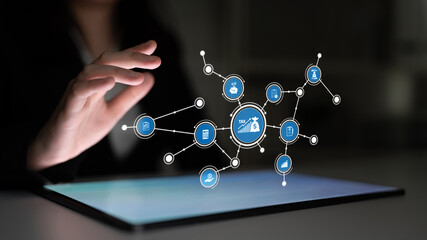 A close-up of a hand interacting with a digital tablet showcasing financial icons and data connections, representing innovation and modern technology in finance. Tessel