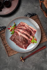 Raw Beef Slices on Plate with Chopsticks.