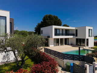 Aerial view of two stunning modern luxury villas with private swimming pools, elegant architecture,...