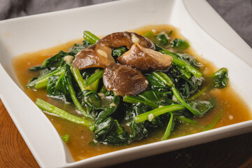 Stir-fried Spinach with Mushrooms in Savory Sauce.