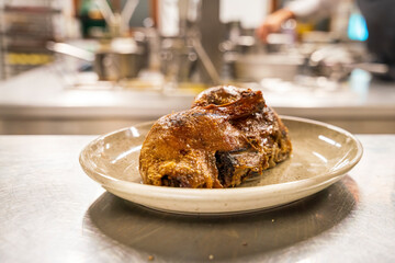 The restaurant kitchen chef prepare a plate with a half roasted duck and Bavarian dumplings 