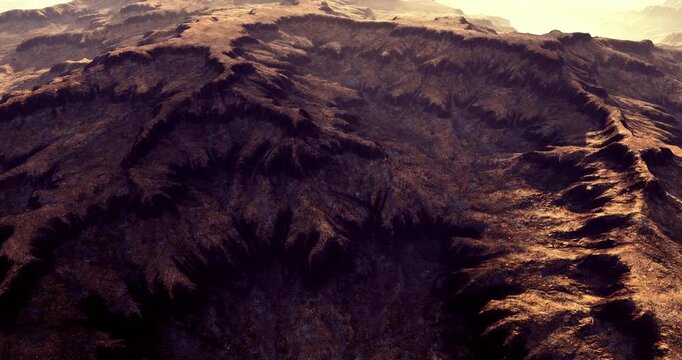 Rugged mountain terrain displays intricate patterns and textures, illuminated by soft sunlight during early morning or late afternoon. Shadows create depth in the landscape, enhancing natural beauty.