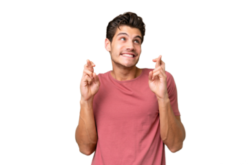Young handsome caucasian man over isolated background with fingers crossing