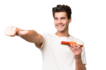 Young caucasian man holding sashimi over isolated background giving a thumbs up gesture