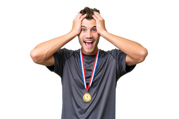 Young caucasian man with medals over isolated background with surprise expression