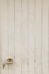 Old white wooden door knocker and keyhole