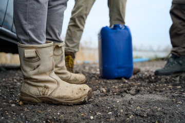 Close-up of men's rugged work boots on a job site, with reinforced toes and heavy-duty soles....