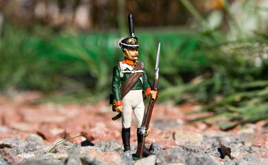 Obraz premium Closeup photo of the toy soldier placed on a gravel in the garden