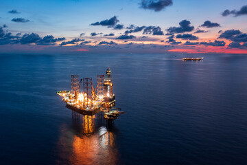 Aerial view of offshore jack up rig and offshore platform during sunset for oil and gas exploration...