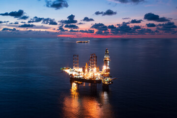 Aerial view of offshore jack up rig and offshore platform during sunset for oil and gas exploration...