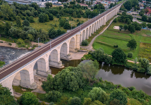 Majestic stone arched railway viaduct over the Bobr river in Boleslawiec, Poland. Historic masonry bridge architecture and river landscape in Lower Silesia region.
