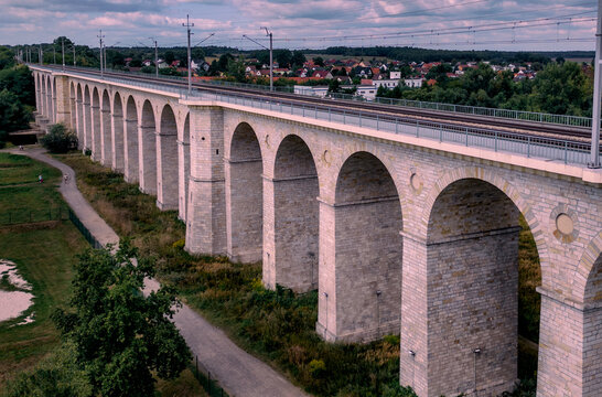 Majestic stone arched railway viaduct over the Bobr river in Boleslawiec, Poland. Historic masonry bridge architecture and river landscape in Lower Silesia region.