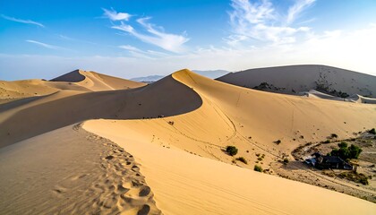 Arid landscape Sand dunes, footprints leading to the horizon beneath a blue sky with whispy clouds on a sunny day