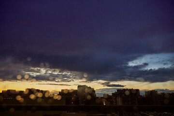 Dramatic Ominous Sky and City Silhouette at Dusk with Rain Bokeh