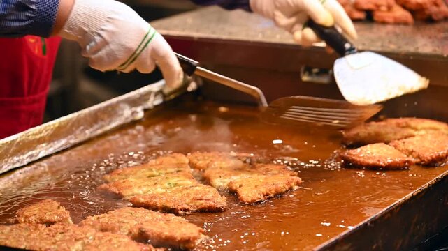 Vendor frying a Bindae-tteok or mung bean pancake at Gwangjang Market in Seoul