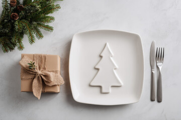 A festive holiday table setting featuring a ceramic Christmas tree plate with ribbon and pine sprig, surrounded by gifts