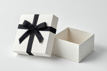 A gift box with a ribbon sits open on a light surface