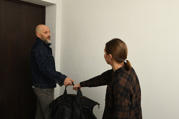 Couple hurriedly packing their belongings and preparing to leave the apartment in a busy moment