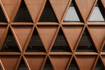 Modern building facade with shaped geometric structure and glass windows.