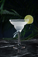 Classic Margarita cocktail with a lime on the dark background