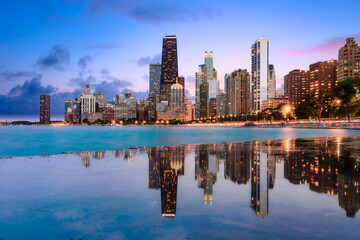 Chicago skyline reflected on Lake Michigan at dusk with illuminated downtown buildings, Illinois, United States