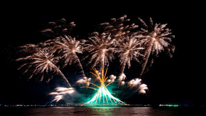 Amazing beautiful colorful firework display over sea on celebration night. Fireworks show for happy new year	