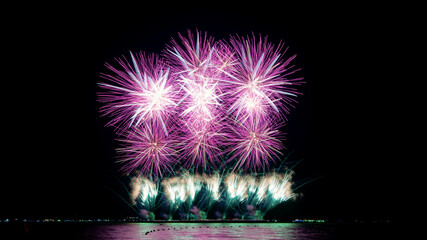 Amazing beautiful colorful firework display over sea on celebration night. Fireworks show for happy new year	