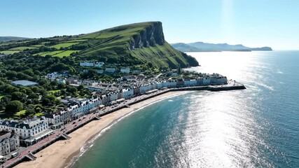 Aerial view of Llandudno seaside town in Wales with green headland and ocean on a sunny day