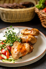 Roasted chicken wings with fresh vegetable salad