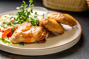 Glazed chicken wings with fresh vegetable salad