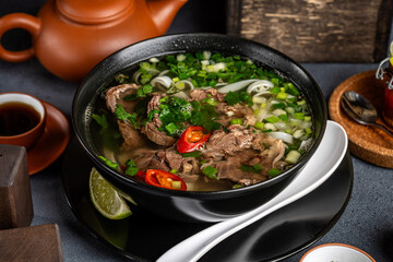Asian beef noodle soup with herbs and chili