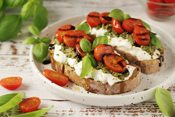 Italian sandwiches with grilled tomatoes, burrata cheese and pesto