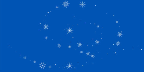 White delicate, lacy snowflakes are carried by the wind against a blue background. Christmas or New Year's background.