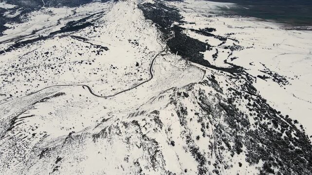 Aerial drone footage flying over the snow-covered Obarenes Mountains in Burgos, Spain, revealing a pristine winter landscape, remote wilderness, and untouched nature with no people. 