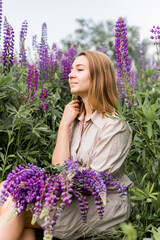 Female portrait in nature with blooming lupines
