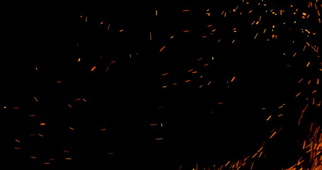 Realistic fire sparks flying through the air, isolated on a black background. Perfect as a...