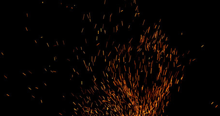Realistic fire sparks flying through the air, isolated on a black background. Perfect as a cinematic VFX overlay, fire particles effect or visual element.