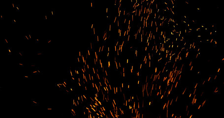 Realistic fire sparks flying through the air, isolated on a black background. Perfect as a cinematic VFX overlay, fire particles effect or visual element.