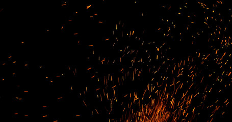 Realistic fire sparks flying through the air, isolated on a black background. Perfect as a cinematic VFX overlay, fire particles effect or visual element.