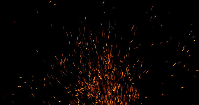 Realistic fire sparks flying through the air, isolated on a black background. Perfect as a cinematic VFX overlay, fire particles effect or visual element.