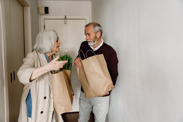 Man and woman holding packages and talking while she gestures