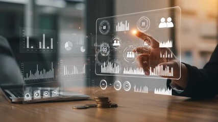 A person interacts with a holographic interface displaying charts and graphs, likely analyzing data, coins, and a laptop are also present - Powered by Adobe