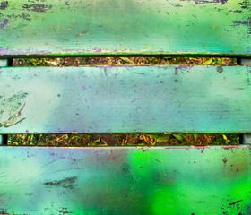 Close-up of a weathered green wooden bench with peeling paint and visible scratches, rustic outdoor texture abstract background with copy space