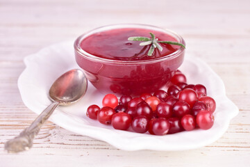 Homemade cranberry sauce on a white wooden background.