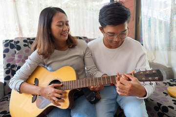 The couple is practicing playing a musical instrument.